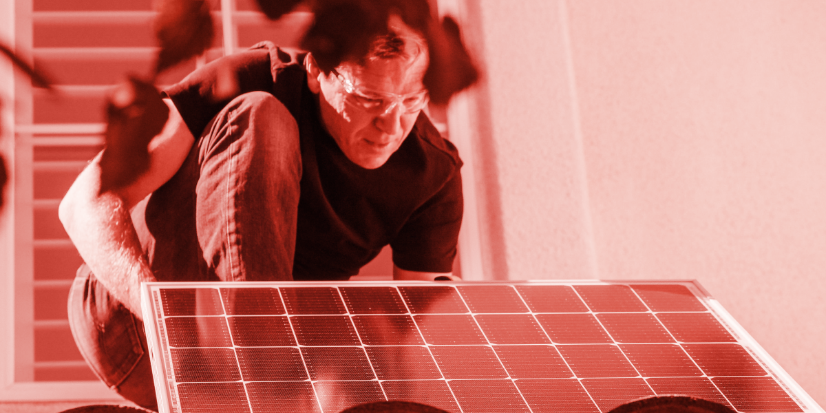Man installing solar panels on a roof